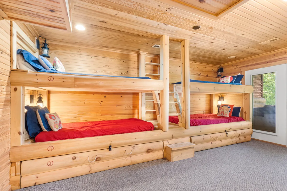 A playful, custom bunk room with sturdy bunk beds, a ladder, and decorative pillows. The setting is bright and welcoming, designed for kids and teens to enjoy sleepovers and storytelling.