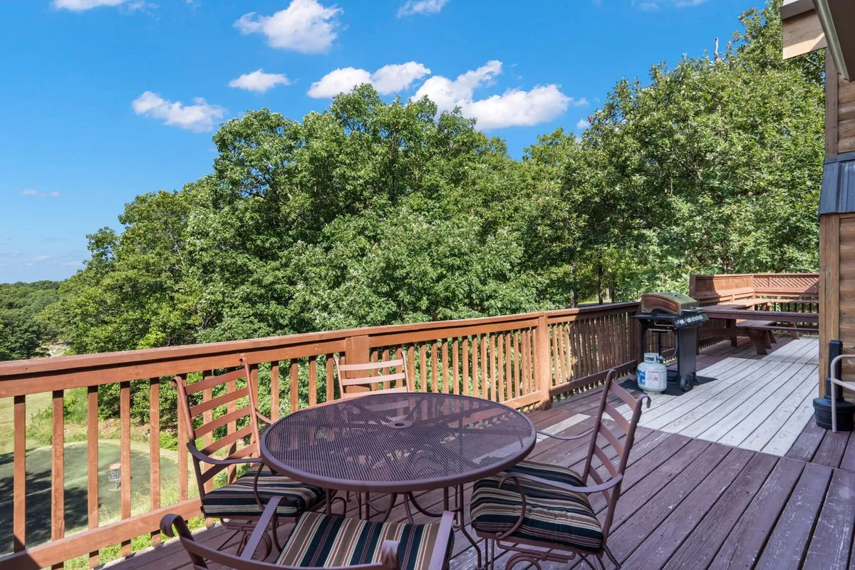 An outdoor seating area nestled in lush greenery, featuring a grill for barbecues and a comfortable setup for dining or relaxing. The setting exudes a laid-back, relaxing vibe, perfect for unwinding after a day of exploration.